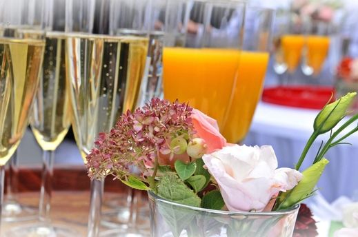 Sektgläser stehen auf einem Tisch hinter Blumen